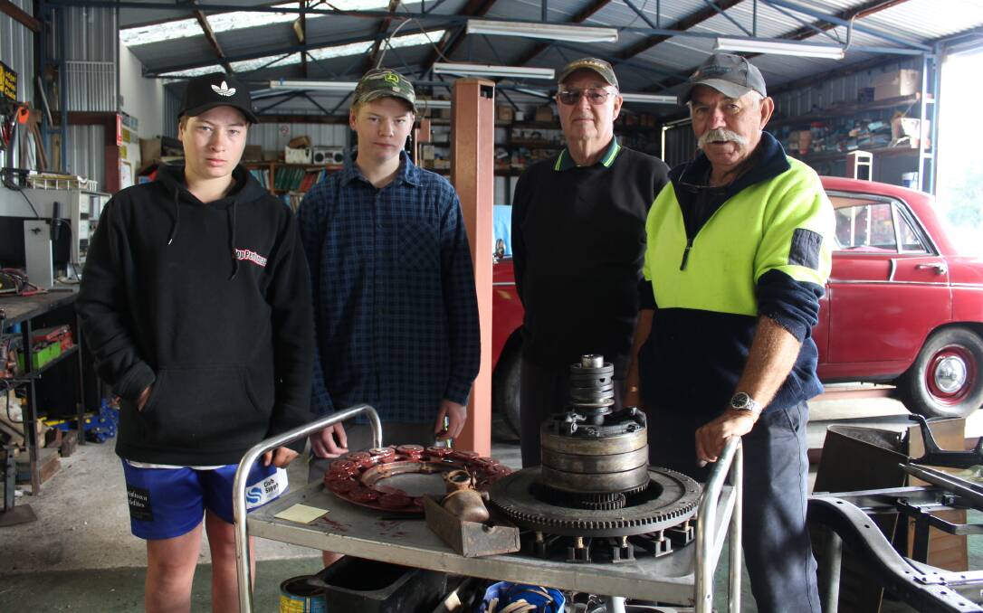 PROJECT: Eden Marine High School Year 10 students Tom Kiely and Matthew Rootsey with Sapphire Coast Historic Vehicle Club members Harry Keys and Denis Kimber in the workshop. Picture: Liz Tickner