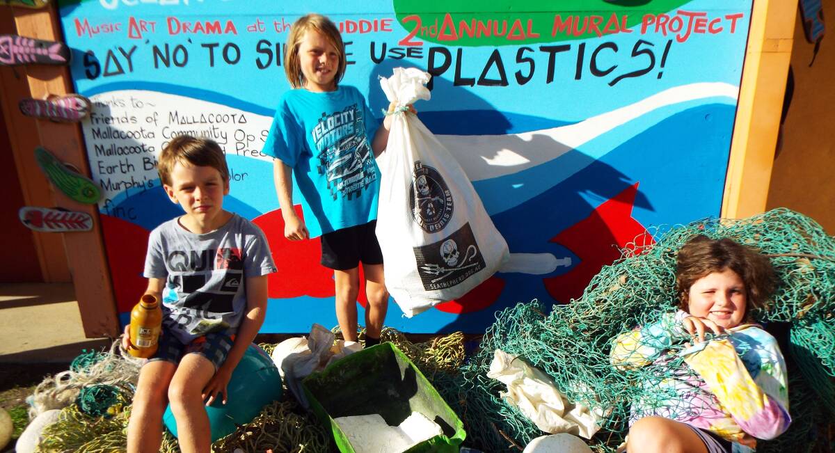 Fynn and Kade Burns, and Unya Boadle get tangled in a display of ocean pollution ahead of the screening of the documentary film 'A Plastic Ocean'.