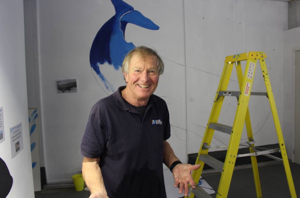 Paul Whittock in the process of painting a whale as part of the Sapphire Coast Marine Discovery Centre's mural on Wednesday, June 13.