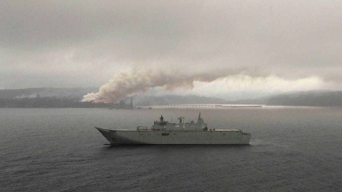 HMAS Adelaide operates off the coast of Eden, NSW as fires still burn out of control during Operation Bushfire Assist. Photo: ADF / POIS Helen Frank