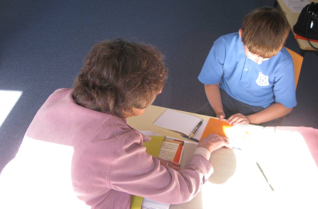 Helping hand: Volunteer tutoring the MULTILit program at Cobargo School. Photo: Supplied.