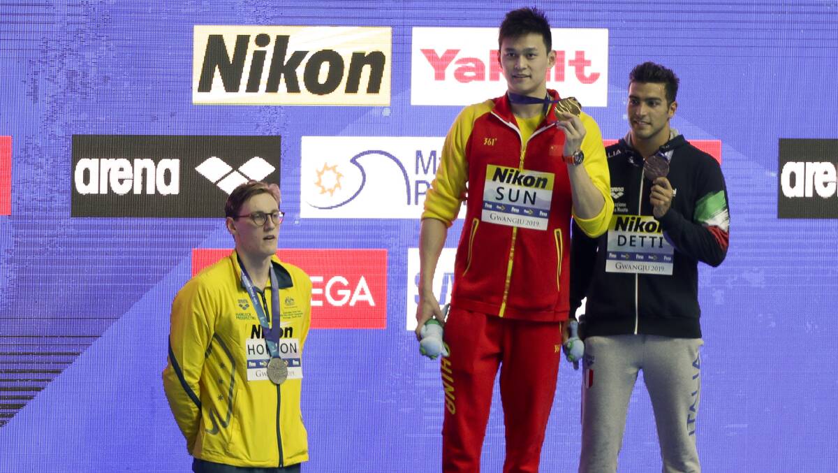 China's Sun Yang, centre, holds up his gold medal as silver medalist Australia's Mack Horton, left, stands away from the podium with bronze medalist Italy's Gabriele Detti right, after the men's 400m freestyle final at the World Swimming Championship Picture: AP