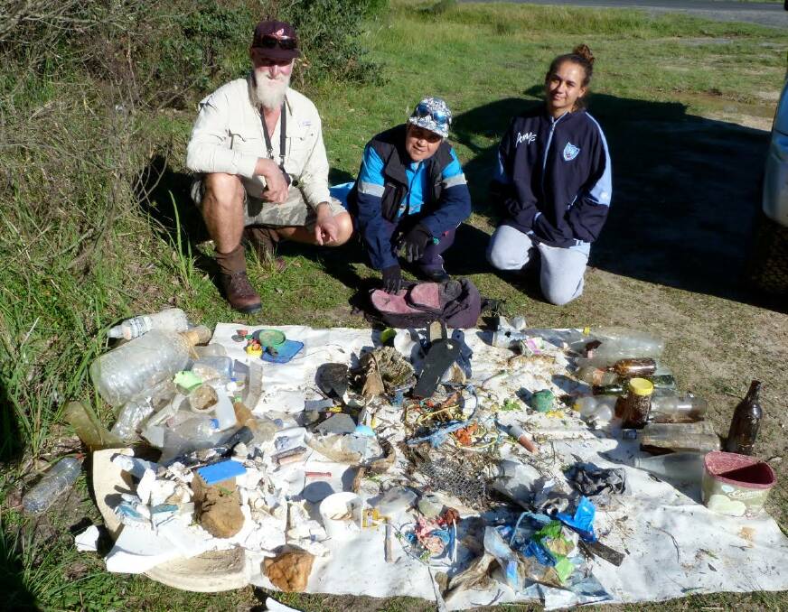 COASTAL CLEAN UP: Coast Weeds Project officer Stuart Cameron with Merrimans Local Aboriginal Land Council members Yuin Kelly and Loanna Panton and garbage collected from Wallaga Beach North.