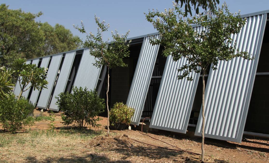 Architecturally designed corrugated iron wraps around the back and sides of the home, sheltering the air-conditioning units and pathways.
