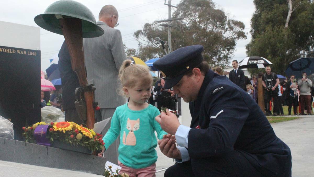 David Franklin offering his daughter, Isabel, a sprig from his wreath to lay at the Eden cenotaph on Anzac day 2017.