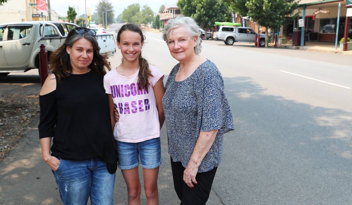 FAMILY UNDER FIRE: Angie, Sapphire and Ann Perkins watched the fire trucks patrol around their home in Adelong until the early hours of Saturday morning. Picture: Emma Hillier