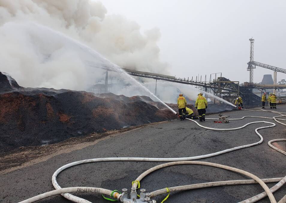 Fire fighters work on the blaze at the Eden chip mill.