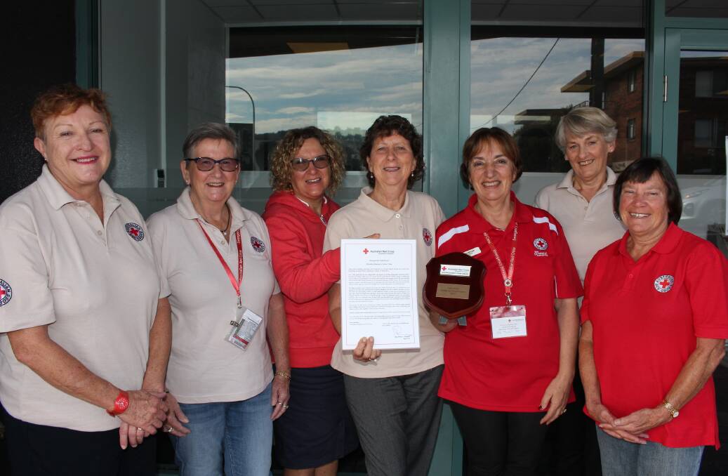 Merimbula team Red Cross volunteers Jenny Balfe, Di Petty, Sharon Tapscott, Helen Williamson, Loretta Fella, Jenny Robbins and Sue Muffler with their citation and award.