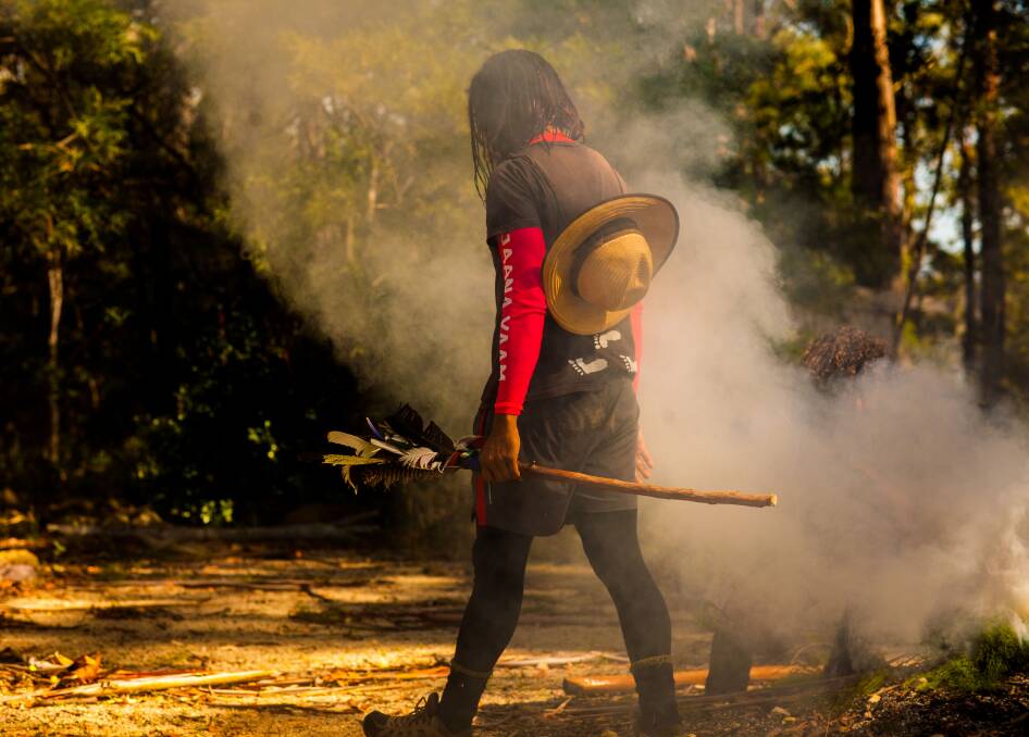 Welcome to Country: Alwyn Doolan walks through the cleansing smoke holding the One Nations message stick. Photo: Rachel Mounsey