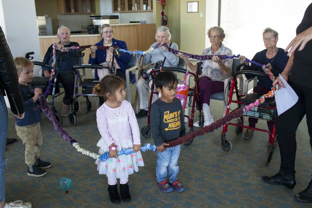 Residents join in a circle time game at the playgroup. Photo: Rachel Mounsey