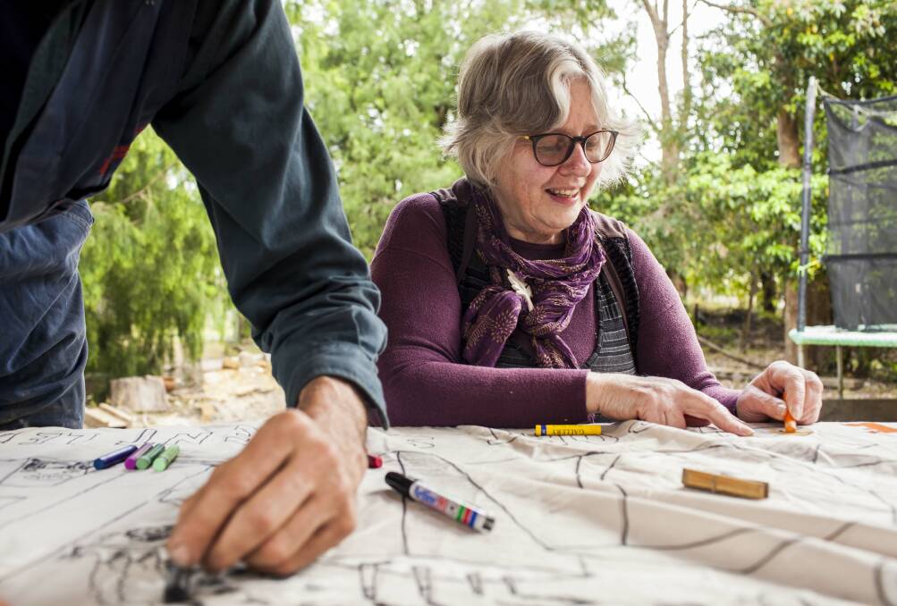 Retired teacher Lorelle Roberts colouring in the banner she will take to the Global Strike4Climate. 