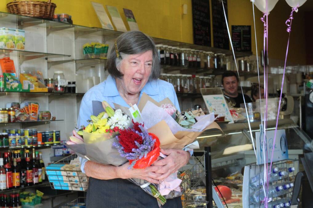 Flowers Galore: Betty Buckland receives armloads of flowers from customers and friends at her morning tea farewell on Friday morning. 