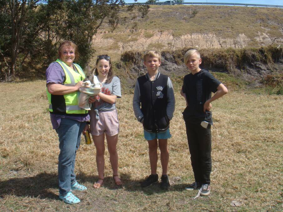  Kids to the rescue: "Lucky" joey pictured with wildlife carer Janine Green and children Ella Cox, Campbell Lovatt and Banjo Bird who raised the alarm after finding her down a two metre deep hole in Merimbula. Photo: Supplied. 