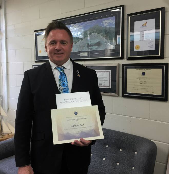 Outstanding: Eden Marine Highschool principal Adrian Bell hold his recently awarded Distinguished Service Award 