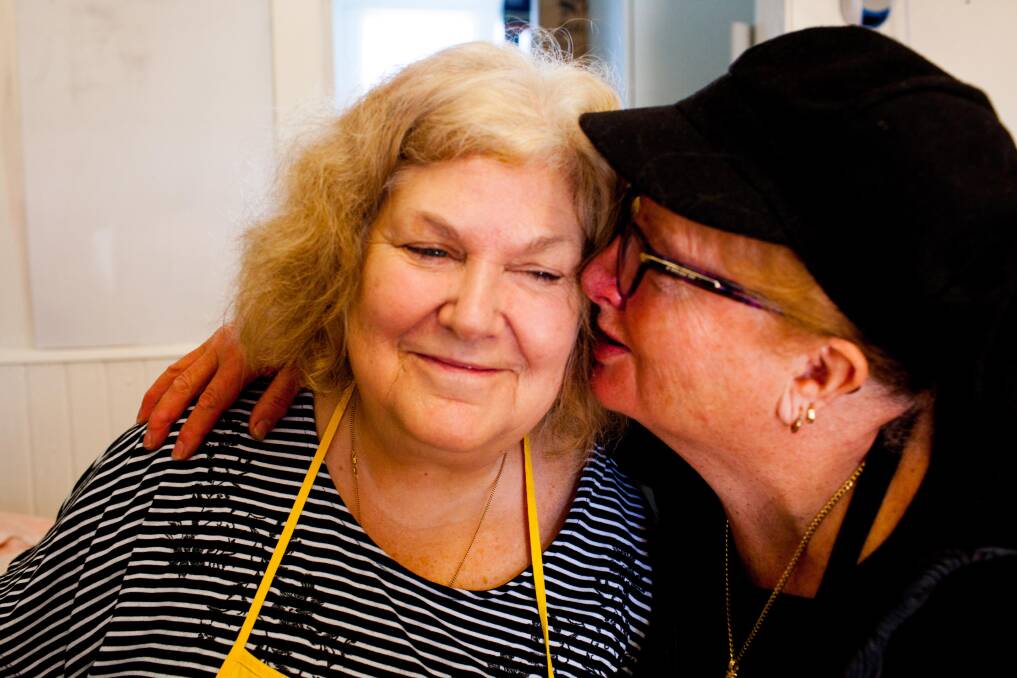 SHARING COMMUNITY: Nicole Griffiths receives a kiss from Bonnie Ferguson in between washing dishes at the Eden Community Kitchen. Picture: Rachel Mounsey