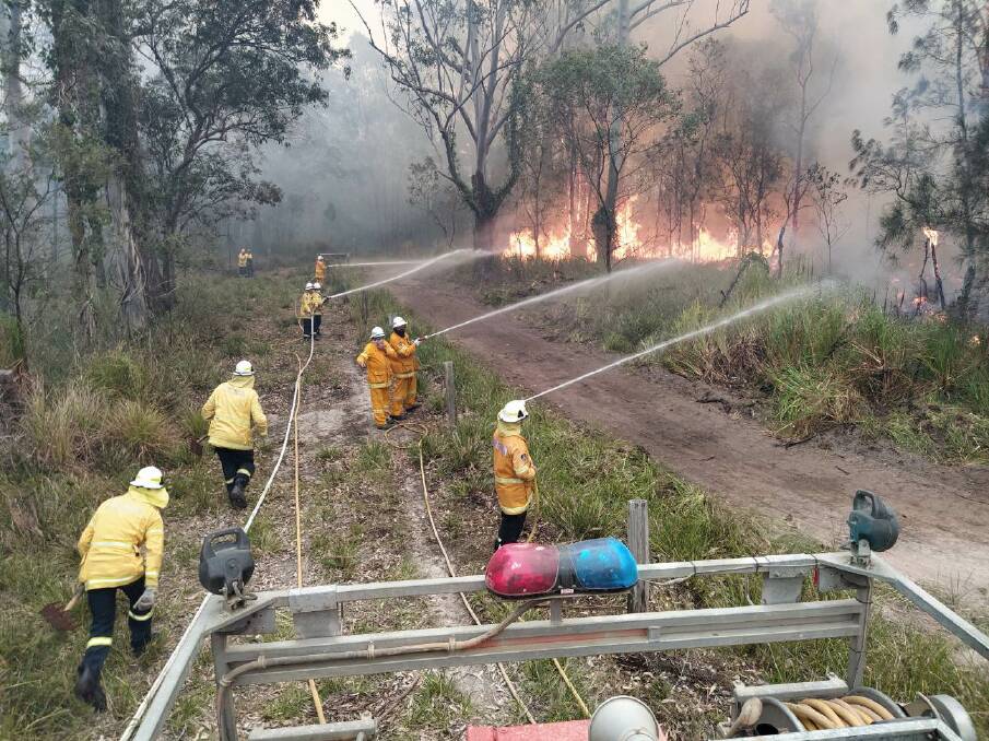 FIREGROUND: Eden volunteer firefighters join strike teams made up of composite groups from several South Coast brigades fighting fires in the Shoalhaven and further north. Photo: Don Firth