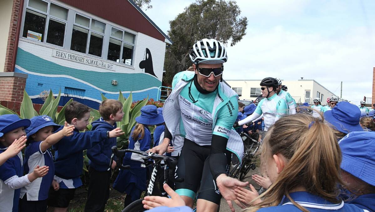 Give me five: Cyclists from the Bondi2Brighton Ride to remember pass through a guard of honour at the Eden Public School. Photo: Rachel Mounsey