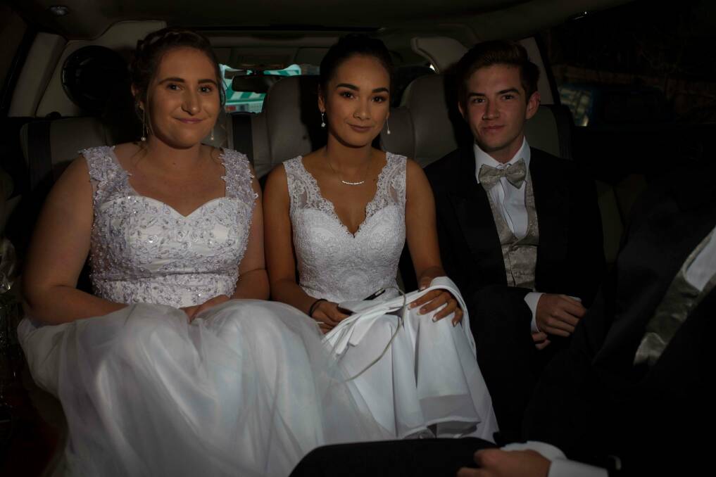 Arriving in style: Mia Edwards, Krystal-Ana Cruse and Brock Doyle head off to the ball in a limousine. Photo: Rachel Mounsey
