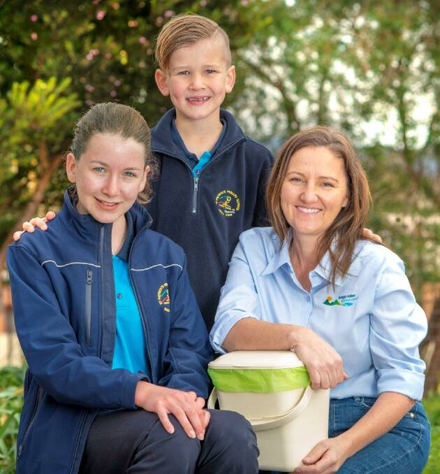 Council’s waste management coordinator Joley Vidau shows St Patrick’s Primary School pupils Lily Mark and Blake Taylor how to use the kitchen caddies which council will deliver to residents when it introduces FOGO in late October.