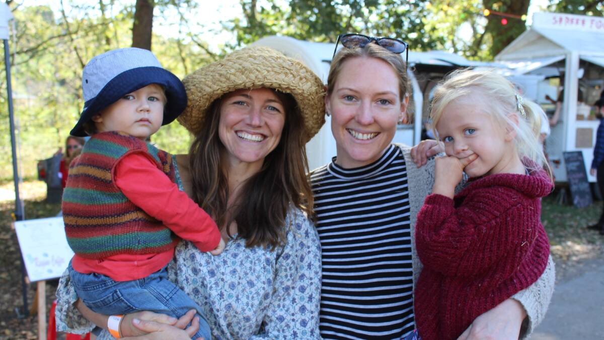 FESTIVE SPIRIT: Bermagui's Sulei and Jade Fowler walk around the Candelo Village Festival on Saturday with Sam and Isla Foster.