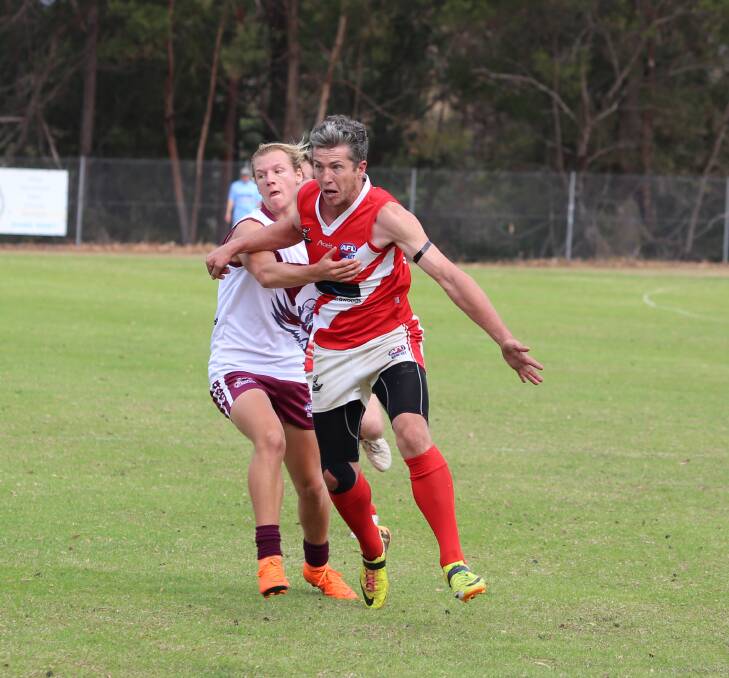 Contender: Whaler Scott Munday gets a kick away during a tackle attempt by Tathra new addition Billy Stubbs on Saturday. 