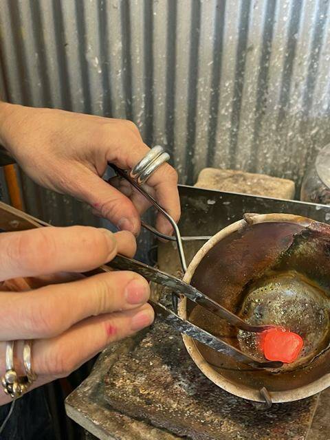 Smelting metal so it can be forged anew as a wearable piece of art.