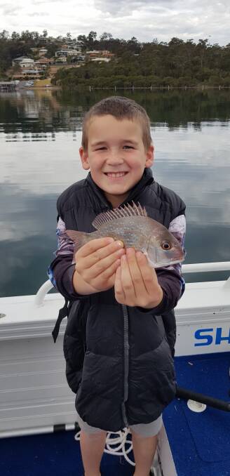 School holiday fun: Eight-year-old Hayden Boyle of Wangaratta, Victoria, shows his first ever catch-and-release snapper in Merimbula Lake.