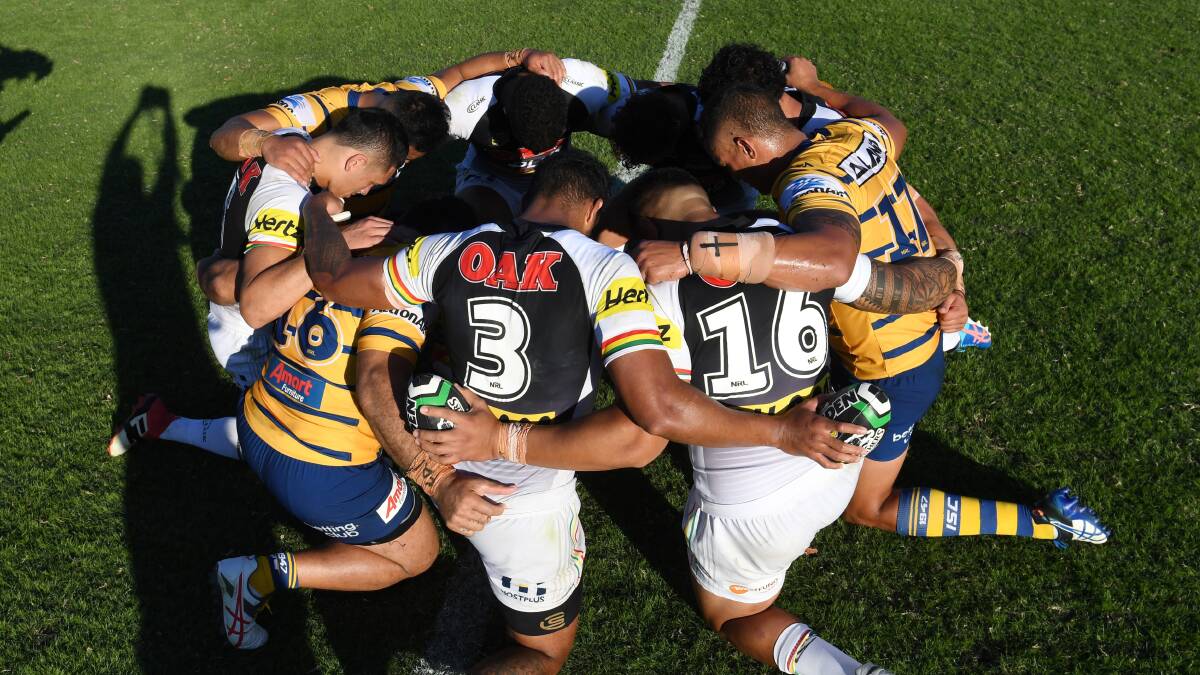Reaching out: Players from the Panthers and Eels share a prayer for fire-affected areas with both clubs supporting the Bega Valley ahead of a trial match. Picture: NRL. 