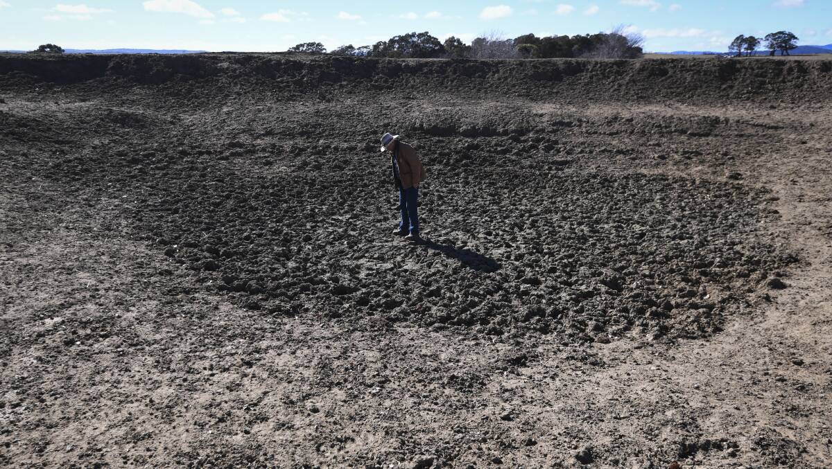 Mark Horan inspects a dried out dam on Bedervale farm near Braidwood. The NSW government on Wednesday declared 100 per cent of the state is impacted by drought, on the back of a drier-than-expected start to winter. Picture: Lukas Coch
