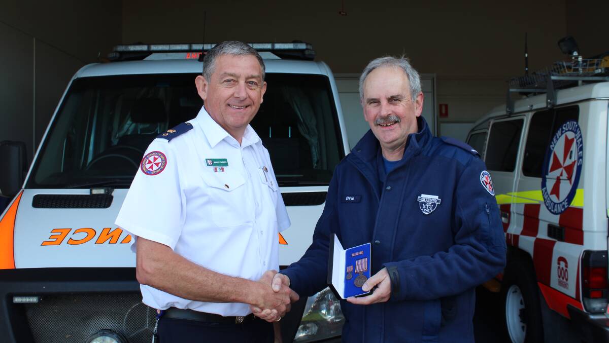 Award: Southern NSW zone manager Mark Gibbs presents Eden paramedic Chris Robinson with the National Medal for 15 years service to NSW Ambulance. Photo: Zach Hubber