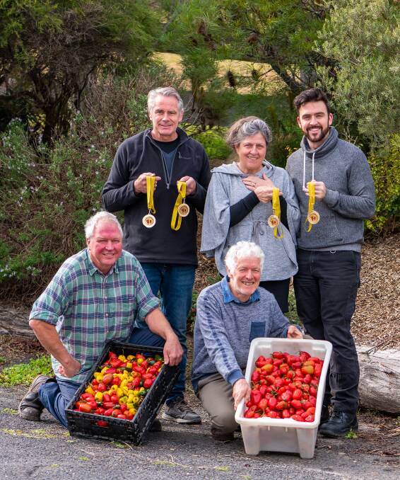 CHANGING HANDS: New owners Les, Letitia and Joel Cruikshank with medals won by Stuart Meagher and John Wentworth for their extensive variety of chilli products. 