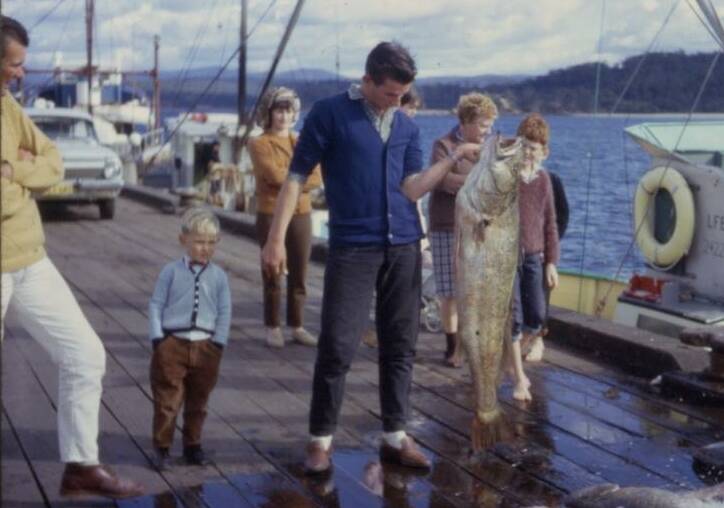 The Whiter brothers are pictured here in about 1968 on the main wharf in Eden, Ian almost out of frame on the left, little Peter in between and Robert holding an enormous catch. Photo supplied.
