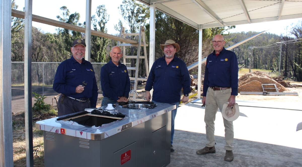 Merimbula Rotary Club members Roger Budd, Shane Osta, Andy Thorp and Bruce Eaton placing the new electric barbecue inside the pavilion. Picture: Denise Dion.