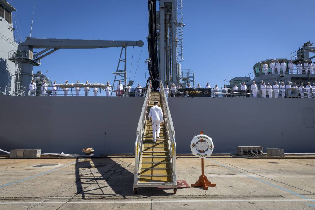 HMAS Supply Commanding Officer, Captain Ben Hissink boards his ship for the first time after her commissioning at Fleet Base East in Sydney, New South Wales.
Photo: Defence.