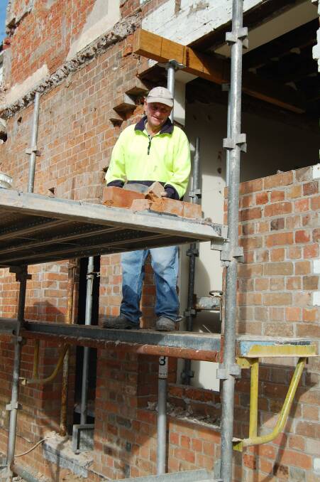 BRICK BY BRICK: Speedy Osborne carefully saving the original bricks to be reused. Photo: Leah Szanto