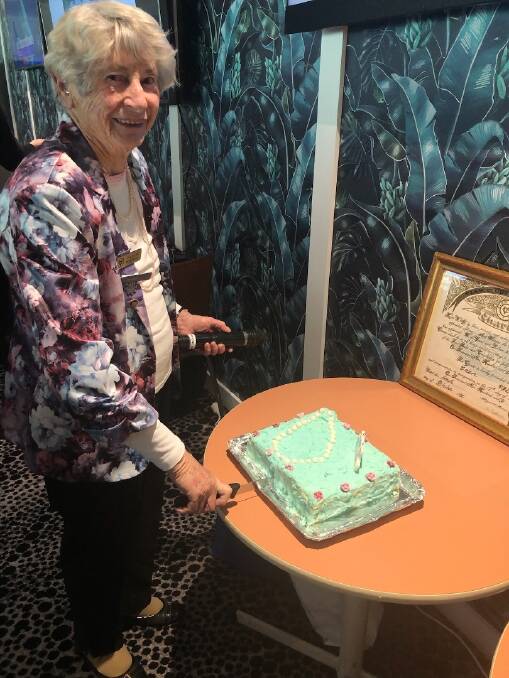 Eden VIEW Club president Pauline Mitchell cutting the birthday cake, with the original charter of the club in the background. Photo supplied.