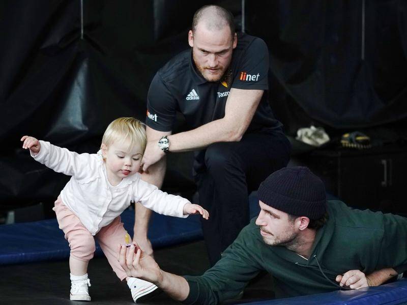 Jarryd Roughead (l) with daughter Pippa and teammate Ben Stratton at Tuesday's press conference.