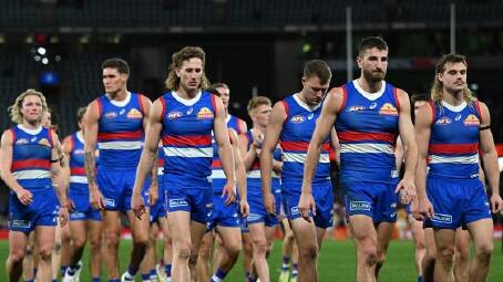 Disappointed Western Bulldogs players trudge off the field after last year's loss to West Coast. (James Ross/AAP PHOTOS)
