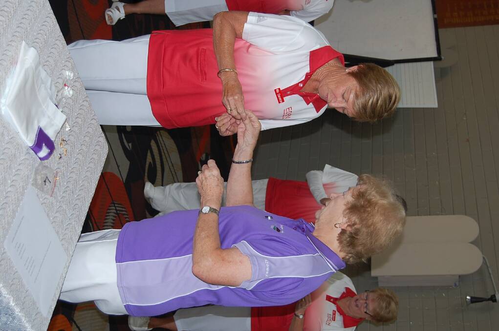 Win Cameron is given her winner’s badge by district president Beryl McGrath-Smith in recognition of her contribution to the team’s grade four Pennant triumph.