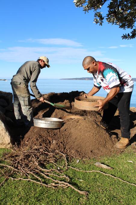 Eden residents Lee Cruse and Darren Mongta sift through dirt on the beachfront, hoping to find more artifacts.   