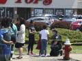 A Buffalo police officer talks to children at the scene of a mass shooting at a Buffalo, New York supermarket on Sunday. Picture: AP