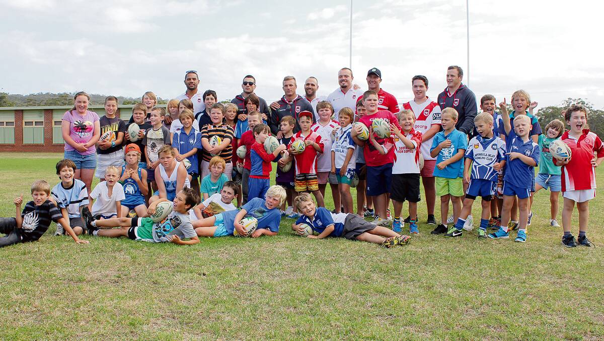 • A group of about 40 kids jump in for a photo with St George Illawarra Dragons stars (back, from left) Willie Mataka, Jack Bird, Josh Drinkwater, Jason Nightingale, Matt Groat, Shaun Timmins and Brett Morris at a training clinic in Pambula on Tuesday.